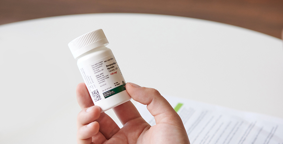 Photo of a person holding a bottle of doxycycine