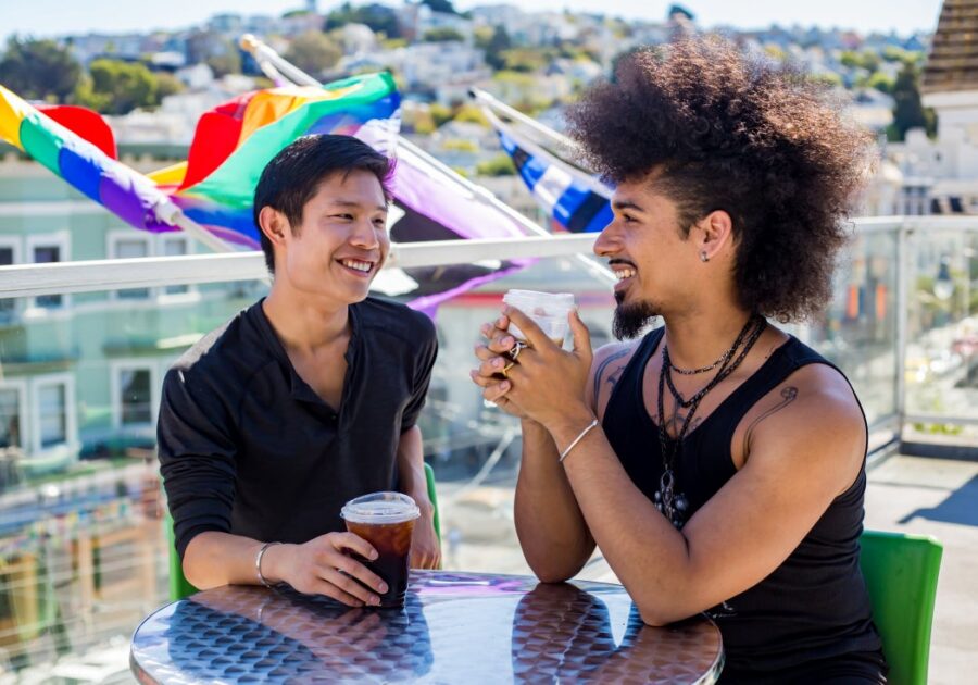 Two people sitting drinking coffee on patio at SFAF health center Strut